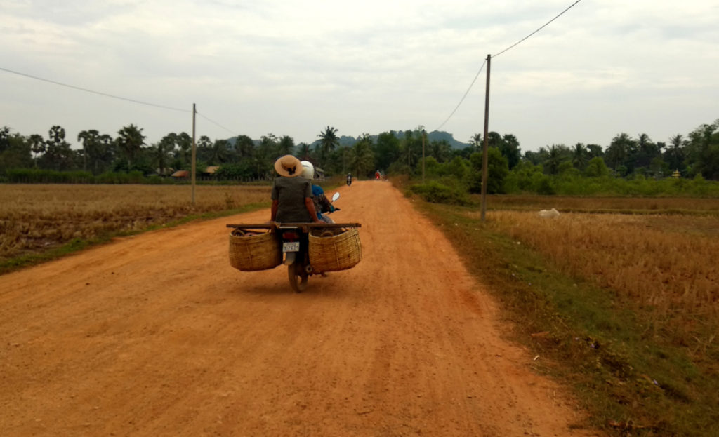 Eine Frau auf einem Roller im Hinterland von Kampot